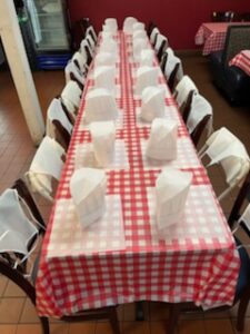 Table and chairs with chef hats prepped to make pizzas